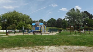 A playground with a blue-roofed playhouse, slides, and swings. - Holiday house with sea view in Hanvec, quiet - 5 people. (Hanvec)