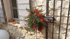 A small garden area with a potted plant, a metal gate, and a stone wall. - Provencal farmhouse with pool  (Joucas)