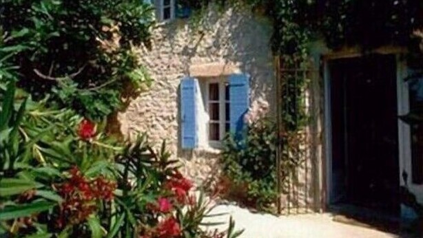 A stone building with a door and window, surrounded by greenery and flowers. - Provencal farmhouse with pool  (Joucas)