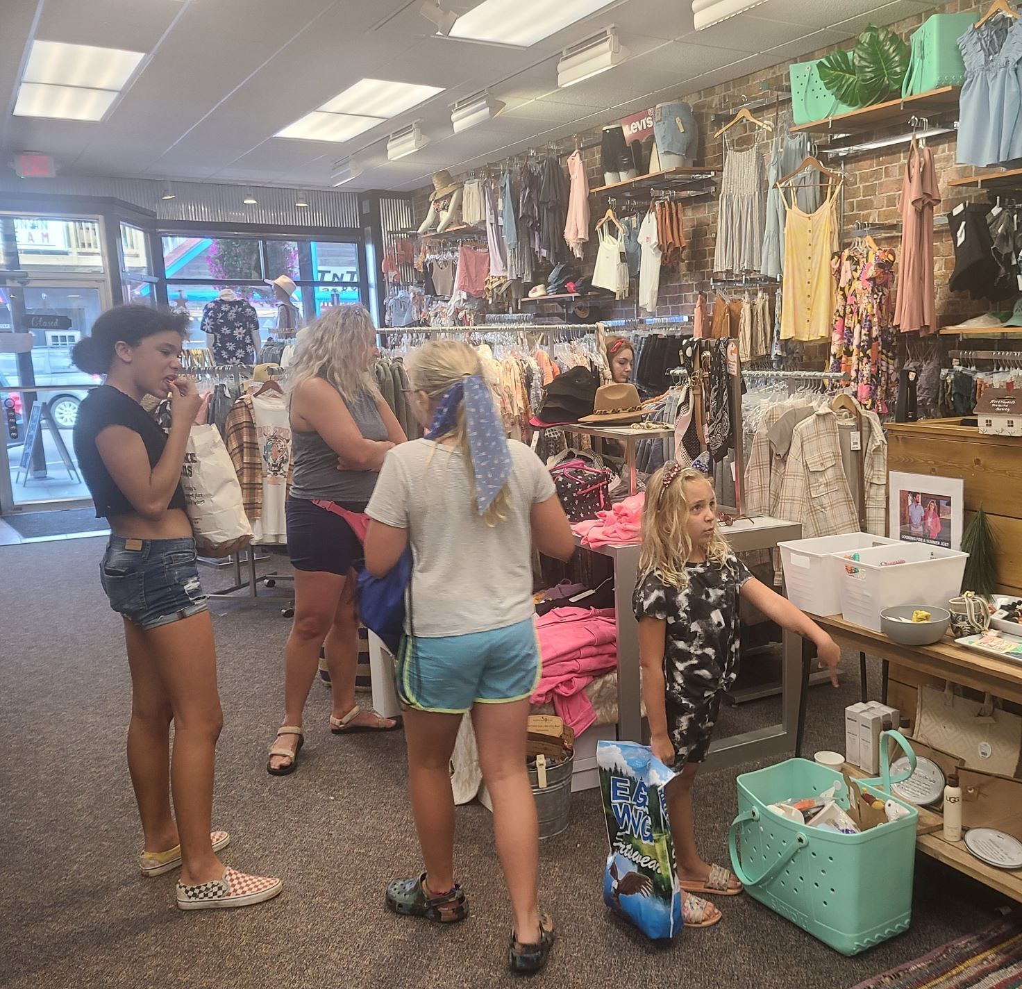 A clothing store with racks of clothes and a checkout counter.