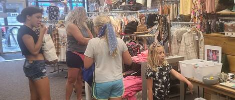 A clothing store with racks of clothes and a checkout counter.