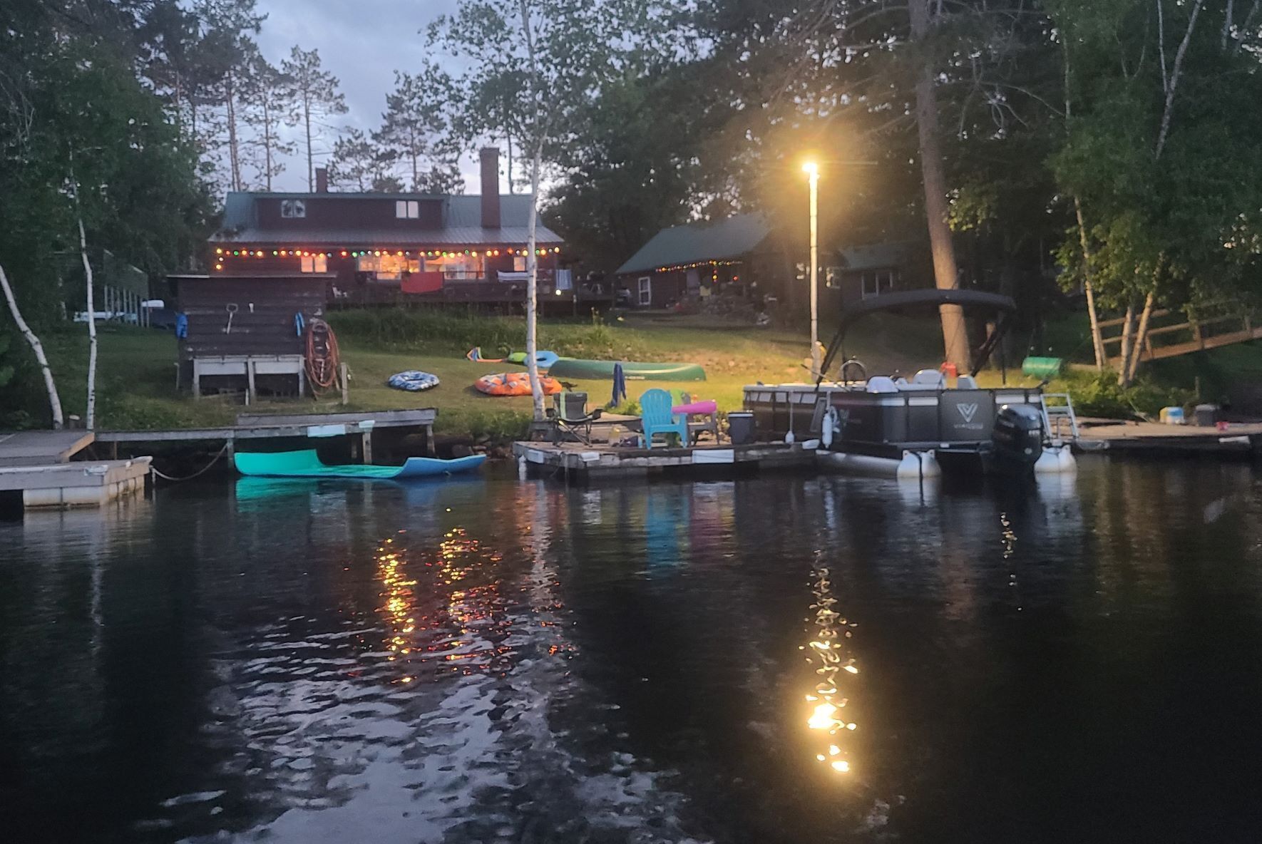 Un bateau amarré, un quai et un bâtiment illuminé.