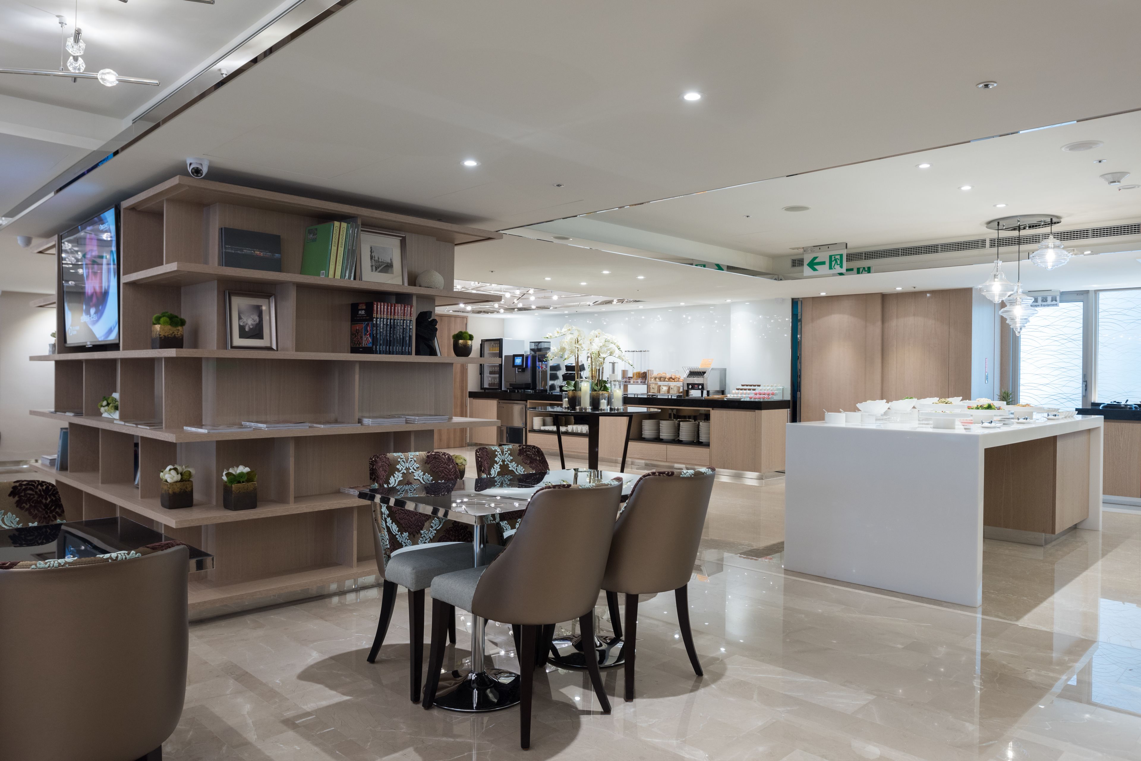 Un moderno vestíbulo de hotel con zona de comedor, mostrador de recepción y un amplio ventanal que proporciona luz natural.