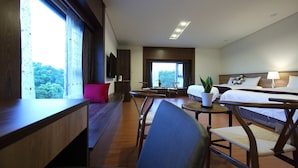 A hotel room with a bed, a desk, a chair, a small table, and a potted plant. - CloudScape (Ji'an)