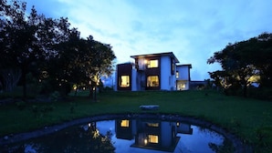 A modern two-story house with a reflection in a pond, surrounded by trees and a well-maintained lawn. - CloudScape (Ji'an)
