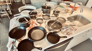 A kitchen counter with various pots and pans, a strainer, and a sink. - Golf Course, Mnt Views, Balloons, King Bed, Veranda, Yard, 3 BD, WIFI, BBQ, WD (Albuquerque)