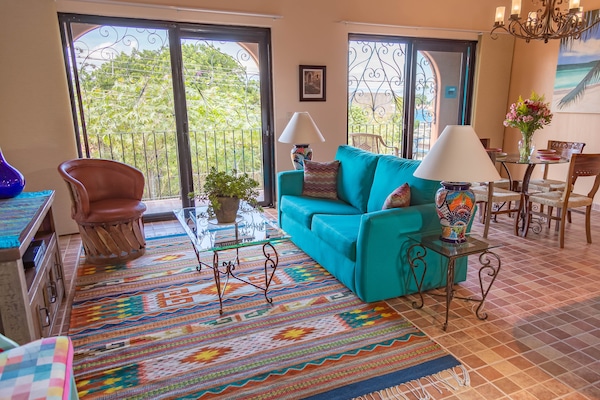 Living and dining area, balcony in background.