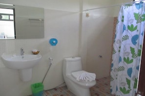 A bathroom with a sink, toilet, and shower curtain. - Arcadian Resort (Krabi)