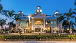 A large, two-story hotel with a central entrance, columns, and a clock tower.