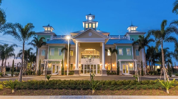 A large, two-story hotel with a central entrance, columns, and a clock tower.