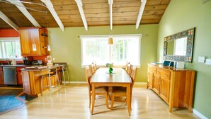 A spacious kitchen with wooden cabinets, a dining table, and a large window. - Perfectly located on the Mountain rd between Stowe village and Stowe Mountain (Stowe)