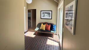 A cozy room with a brick floor, a bench with colorful cushions, a skylight, and framed artwork on the walls. - Perfectly located on the Mountain rd between Stowe village and Stowe Mountain (Stowe)