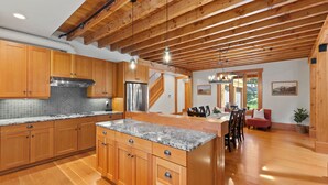 A spacious kitchen with wooden cabinets, granite countertops, and a central island. - Suncadia Retreat • 3 porches • Quiet Cul-de-Sac • Fire pit • Bikes (Cle Elum)