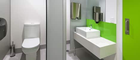 Une salle de bain moderne avec des toilettes, un lavabo et un miroir.