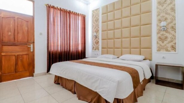 Une chambre à coucher avec un lit, une porte en bois et une fenêtre avec des rideaux.