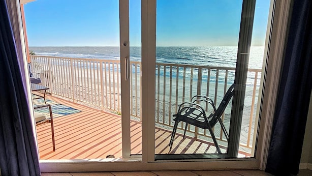 A balcony with a view of the ocean, a chair, and a table. - Beachside Gulf front 3BR,2BA condo in Indian Shores, FL Spectacular Sunsets! (Indian Shores)
