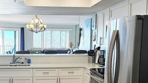 A modern kitchen with white cabinets, stainless steel appliances, and a large island. - Beachside Gulf front 3BR,2BA condo in Indian Shores, FL Spectacular Sunsets! (Indian Shores)