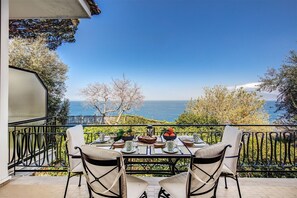 Un balcón con una mesa para dos, con vistas a un paisaje marino.