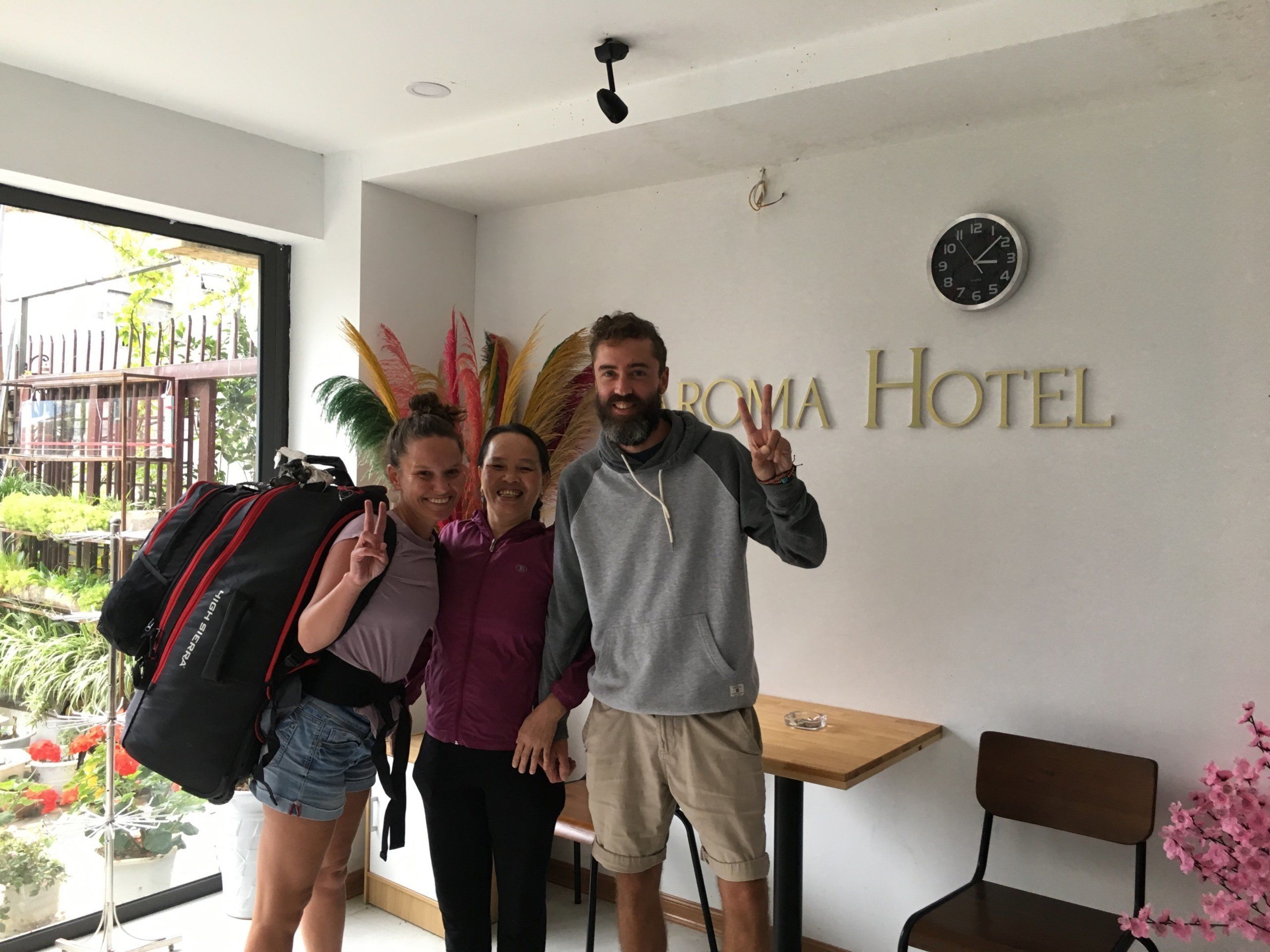 A room with a large window, a clock, and a sign that reads "ROMA HOTEL".