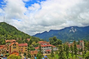 A mountainous village with traditional buildings, a church, and a clear view of the surrounding hills. - Sapa Aroma Hotel (Sa Pa)