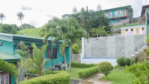 A residential area with houses, a stone wall, and a pathway. - Little Falls Inn (Tagaytay)