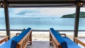 A wooden deck with benches overlooking a beach and the sea. - Octopus Resort (Waya Island)