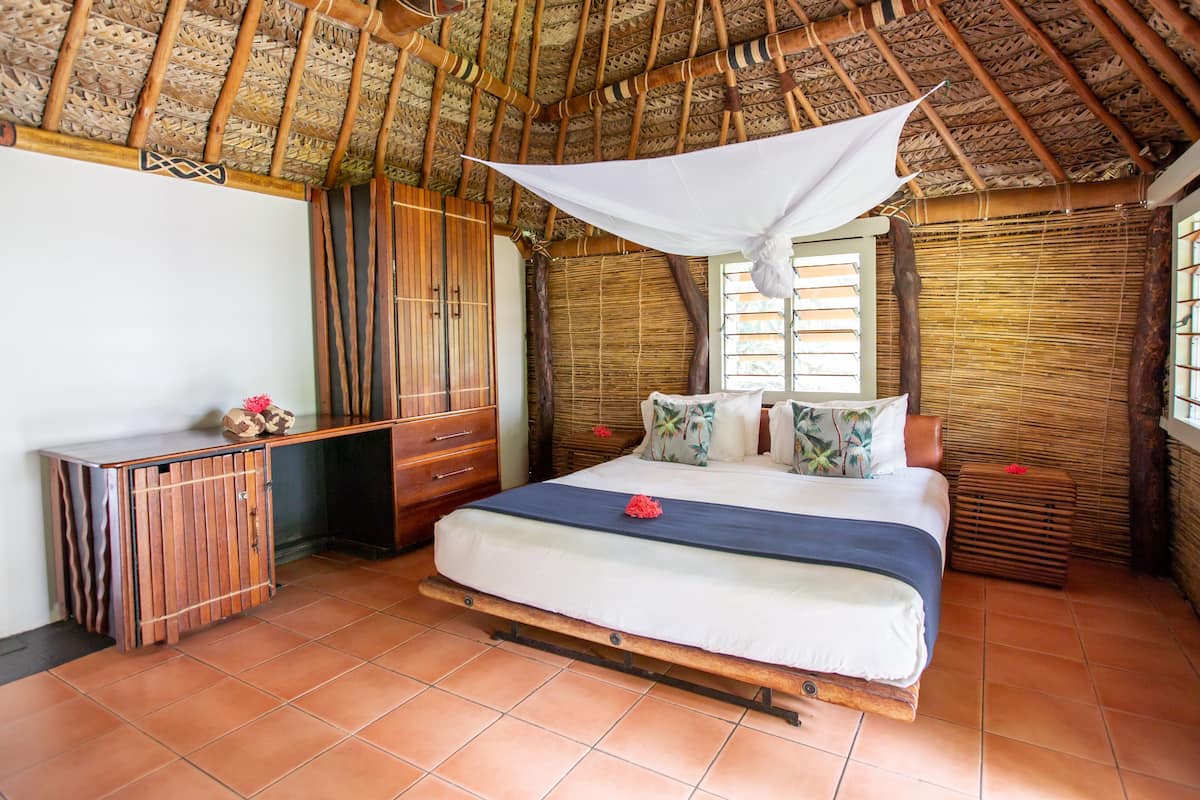 Um quarto com uma cama, uma escrivaninha de madeira e um guarda-roupa.