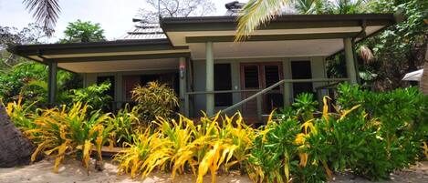 A two-story building with a flat roof and a covered porch.