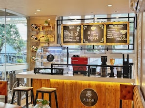 A coffee shop interior with a wooden counter, menu boards, and a coffee machine.