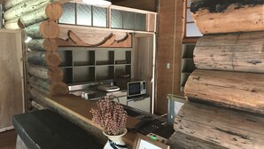 A rustic kitchen with wooden logs, a sink, a microwave, and a vase with dried flowers. - Rulo Classic Garden (Kaiyo)