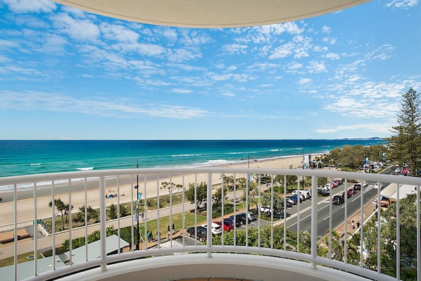 A balcony with a view of a beach and ocean.