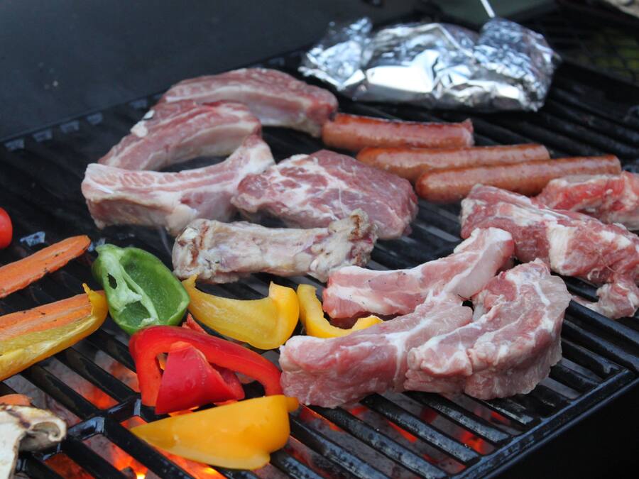 Una parrilla con diferentes carnes y verduras.