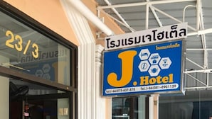 A hotel entrance with a sign for J. Hotel, including contact numbers. - J Hotel (Krabi)