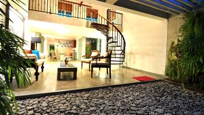 Un espace intérieur vaste, doté d’un escalier, de sièges et d’un sentier pavé de petits galets.