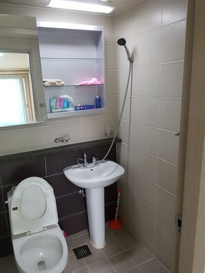 A bathroom with a toilet, sink, and shower. - Woong House (Seoul)