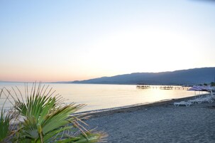 Playa privada, sillas reclinables de playa, sombrillas