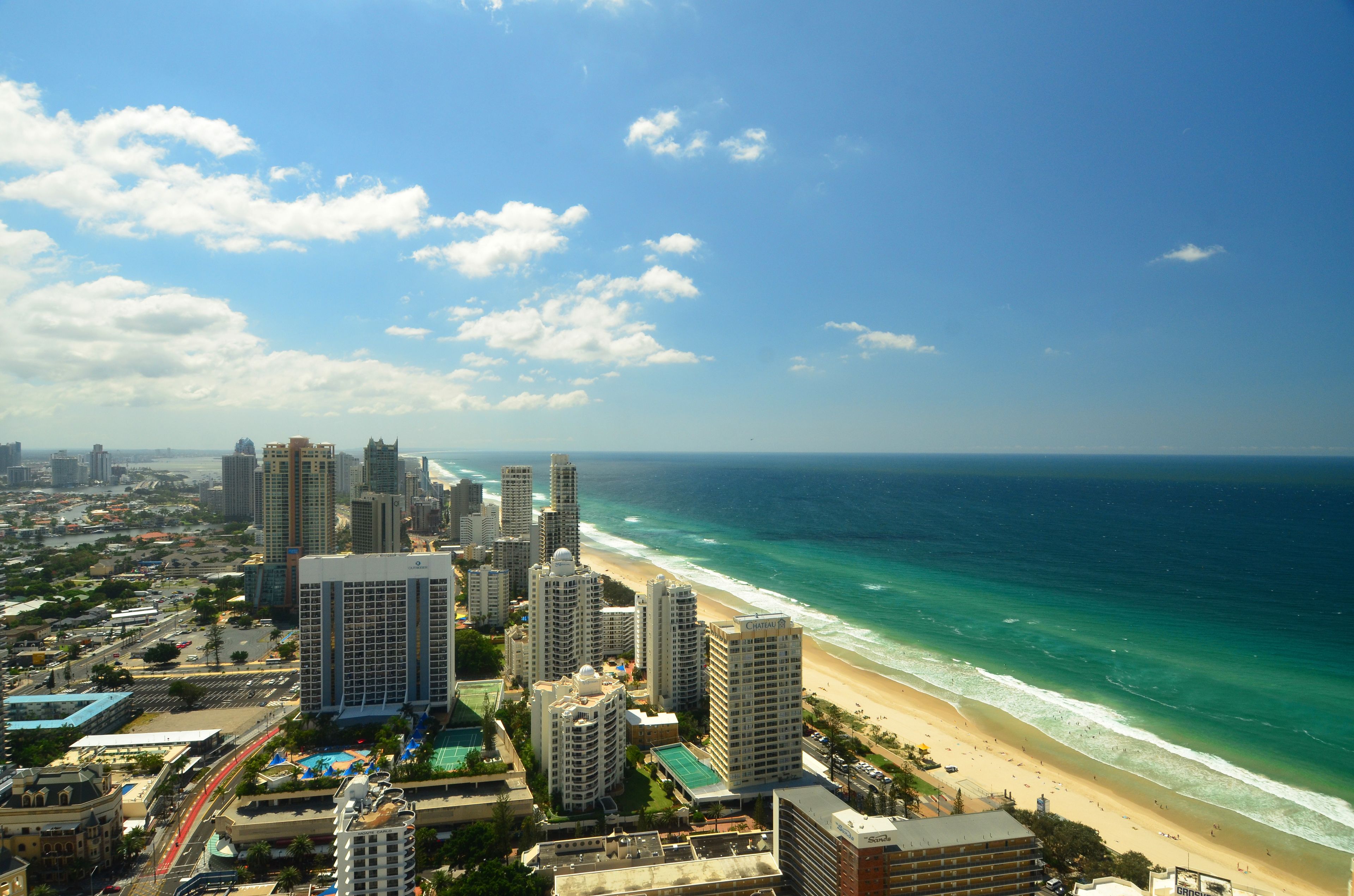 Eine Küstenstadt mit Wolkenkratzern, einem Strand und blauem Himmel.
