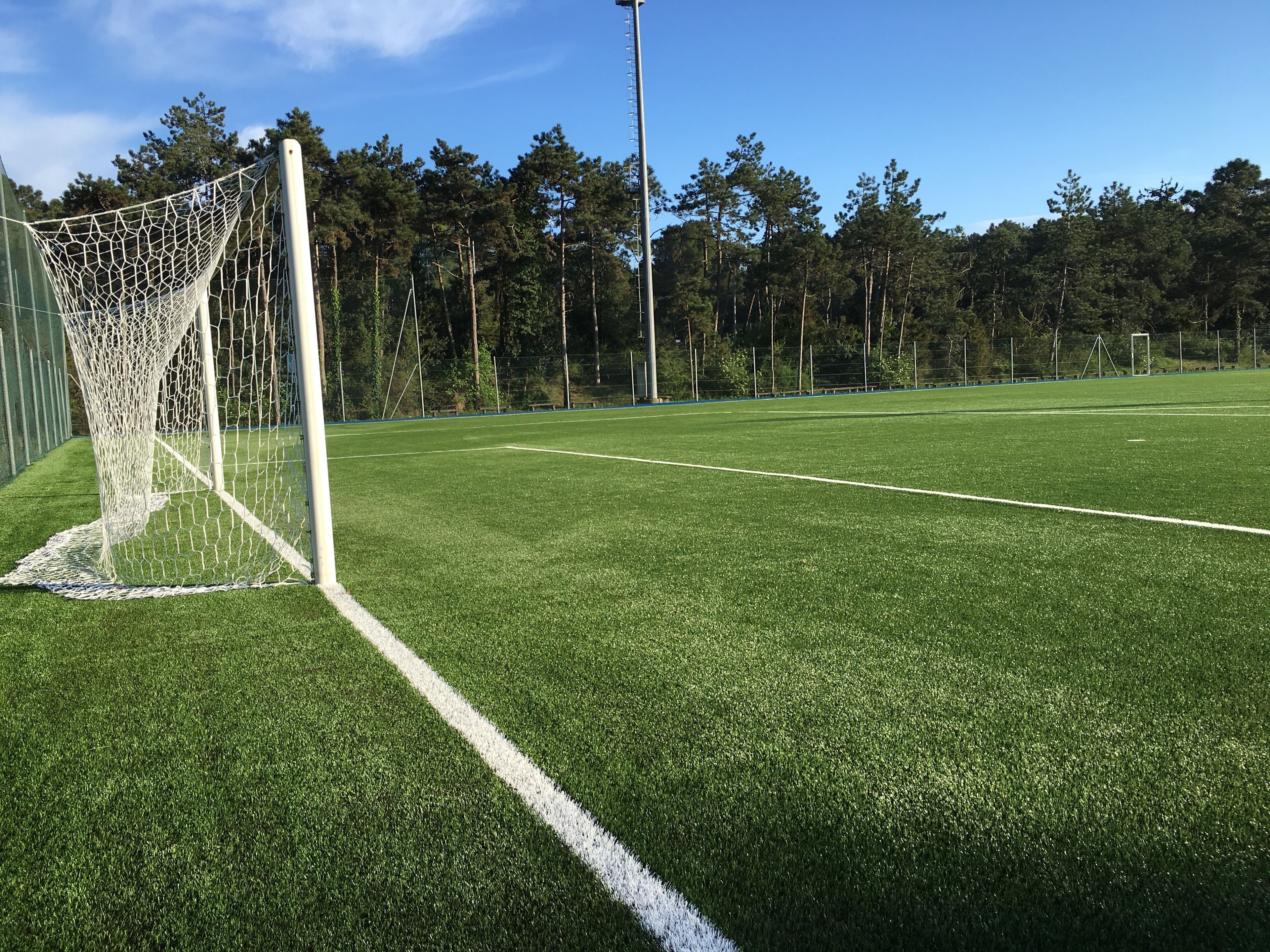 Un campo de fútbol con un arco y un cielo despejado.