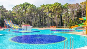 Una piscina con múltiples toboganes y una fuente de agua.