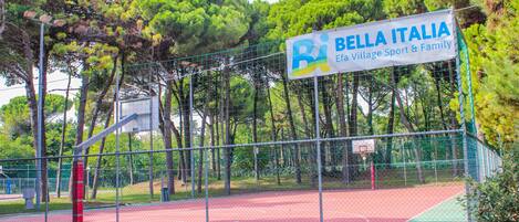 A basketball court with a sign reading "Bella Italia Efa Village Sport & Family".
