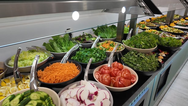 Un bufé con ensaladas y verduras variadas.