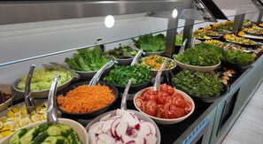 Un bufé con ensaladas y verduras variadas.