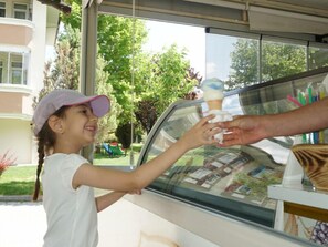 A child reaching for an ice cream cone at a drive-thru window. - Basaranlar Thermal Hotel (Ihsaniye)