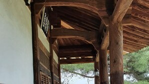 Un corridoio in legno tradizionale con vista su un edificio storico sullo sfondo.