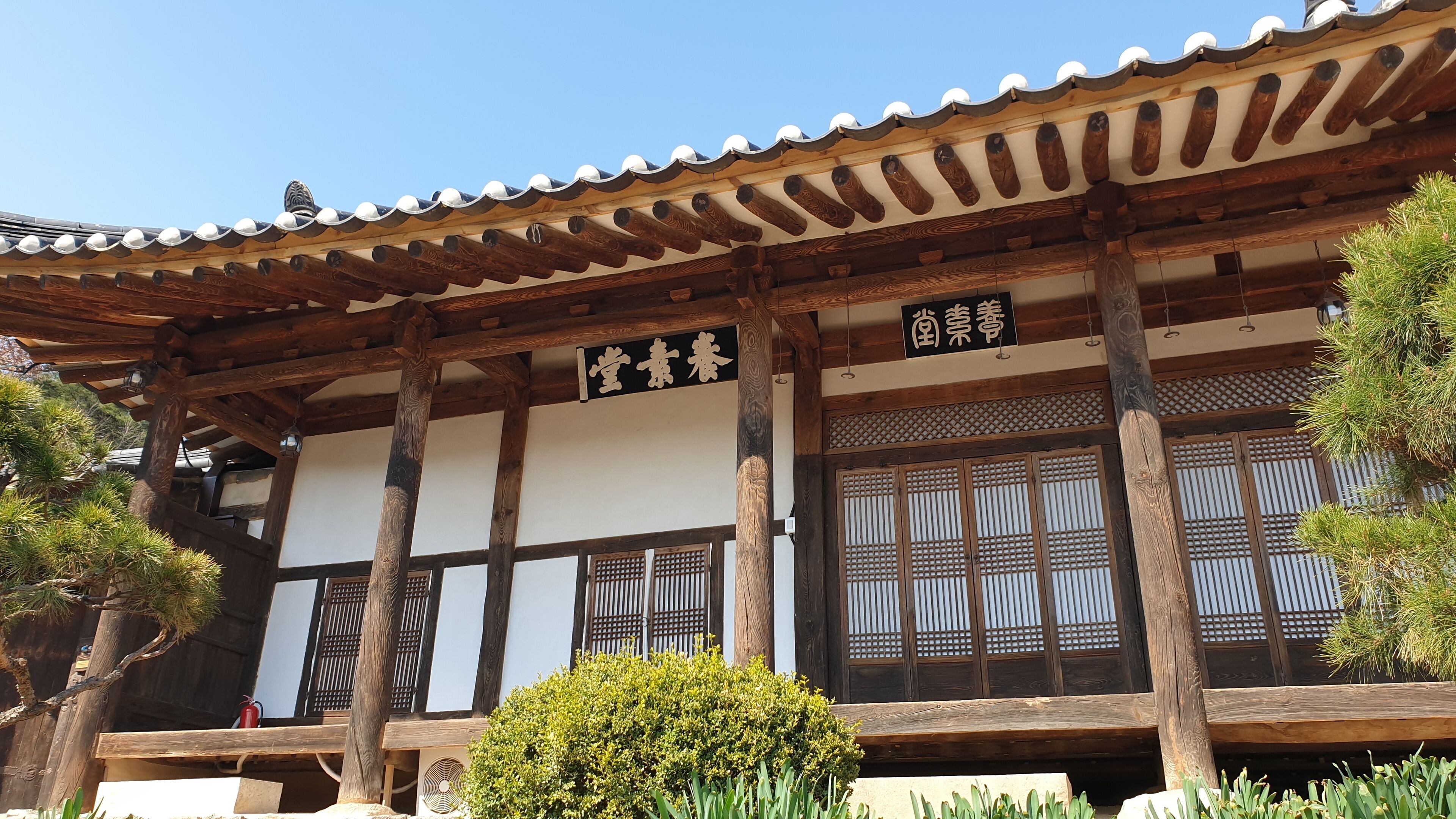 A traditional Japanese building with wooden beams, tiled roof, and large sliding doors.
