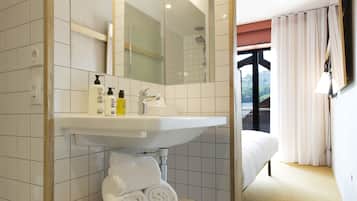 Un baño con lavamanos, espejo y toallero blancos.