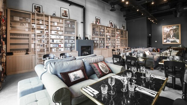 Un interior moderno con un sofá, una mesa de comedor y estanterías.