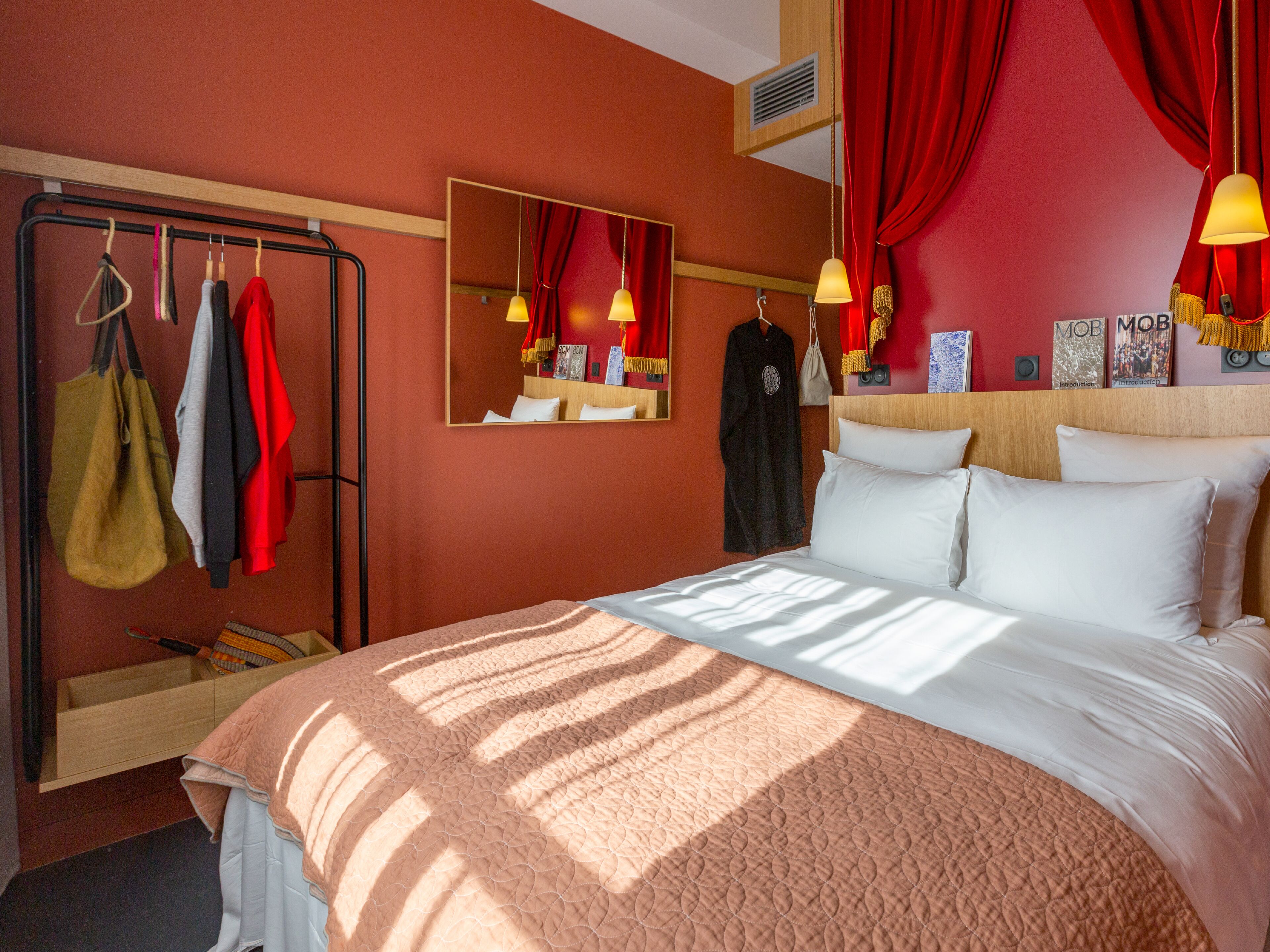 Habitación de hotel con cama, armario y espejo.