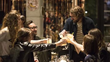 Un groupe de personnes trinquant avec des boissons autour d’une table dans un restaurant.
