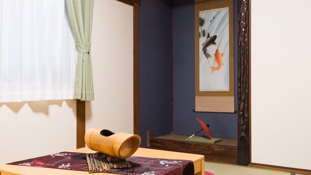 Ett traditionellt japanskt rum med tatamimattor på golvet, ett lågt träbord och en futonmadrass.